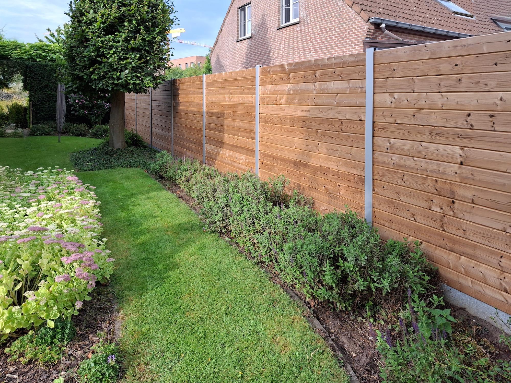 Houten tuinafsluiting Tuinafsluiting in hout, planken tand en groef tussen aluminium palen. Grenenhout.