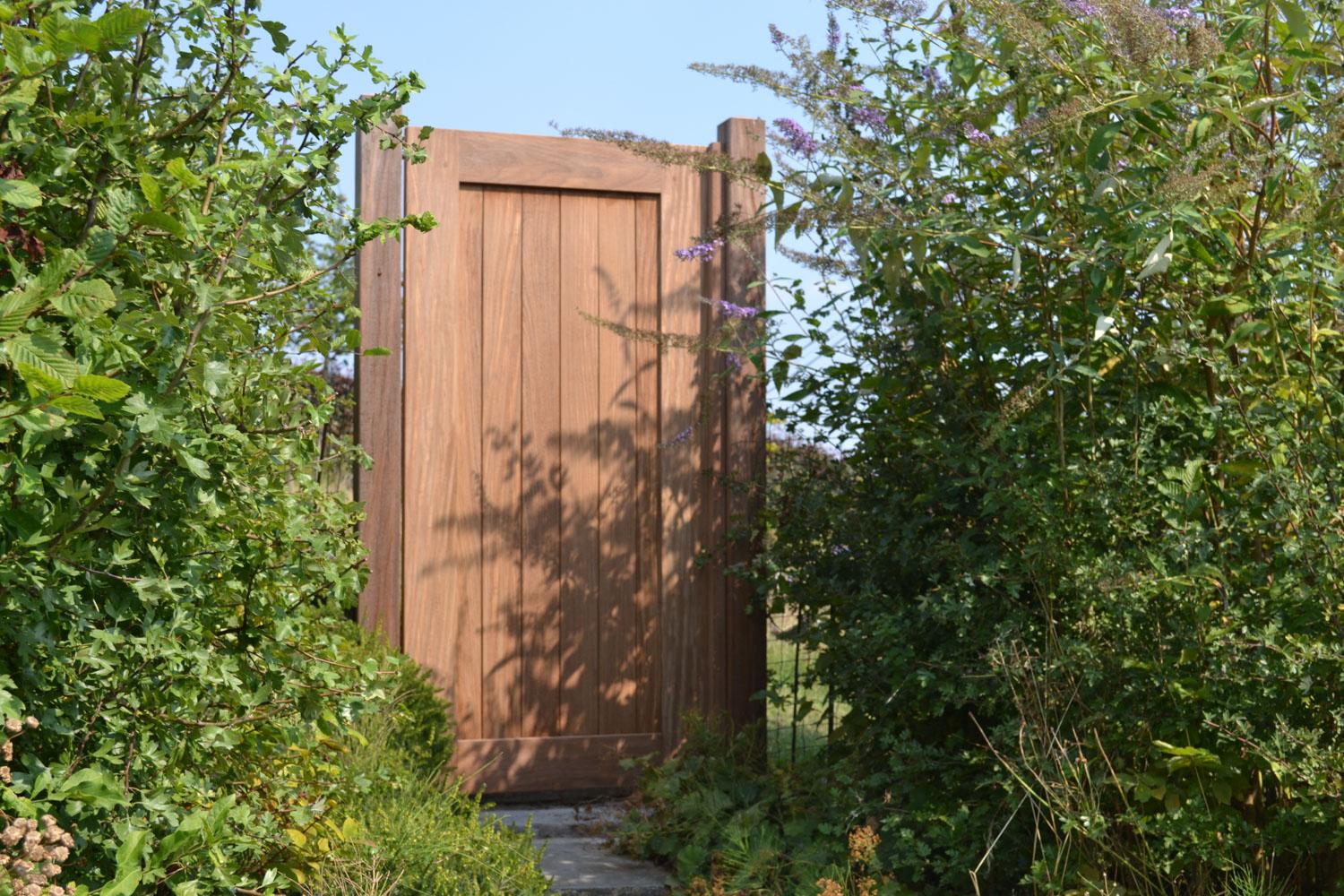 tuindeur Voeg stijl en veiligheid toe aan uw tuin met een duurzame tuinpoort. Beschikbaar in hout (afromosia, padoek, iroko,...), metaal , aluminium en composiet, op maat gemaakt voor een perfecte aansluiting bij uw tuinafsluiting.